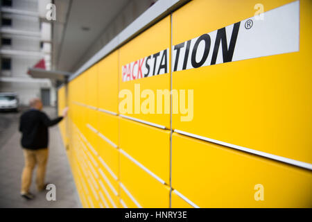 Ein Mann schließt die Tür für eine Parzelle Container Schachtel mit einer so genannten "Packstation", ein Service von DHL, in Berlin, Deutschland, 6. Februar 2017 laufen. Es ermöglicht Kunden, Pakete und Briefe von automatisierten Ständen, auch bekannt als "Packstation" abholen. Foto: Lino Mirgeler/dpa Stockfoto