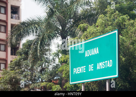 Ein Zeichen liest "Aduana" (Zoll), 'Puente de Amistad" (Freundschaft Brücke) in spanischer Sprache, vor dem Überqueren der Brücke von Ciudad del Este Stadt, Paraguay Stockfoto