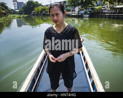 Thepharak, Samut Prakan, Thailand. 16. Februar 2017. Passagiere in einem kleinen Boot, das als eine Fähre nehmen Menschen über Khlong Samrong, am Stadtrand von Bangkok dient. Der Bootsmann zieht es über ein System von Seilen und Rollen. Der Bootsmann hat auf dem Boot gearbeitet, seit er ein Kind war. Kleine Fähren wie dies früher häufig in Bangkok aber viele Khlongs (die Kanäle, die verwendet, um Bangkok zu durchkreuzen) ausgefüllt und Brücken über die verbleibenden Khlongs wurden. Jetzt gibt es nur eine Handvoll Fähren links. Diese Fähre lädt 2 Baht (umgerechnet ca.. 06¢ US) Stockfoto