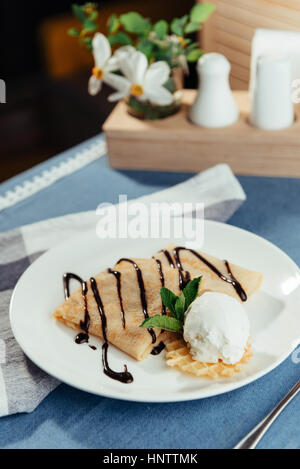 Pfannkuchen mit Eis und Schokosauce. Stockfoto