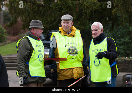 3 reife Männer im Chat, tragen hi-Vis Westen (alle Ilkley Rotary Club-Mitglieder) helfen bei der Organisation einer Veranstaltung, Ilkley, West Yorkshire, England. Stockfoto