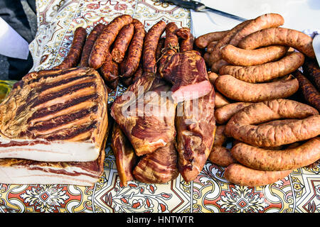 Hausgemachte Würste, Schinken und Speck auf dem Tisch zum Verkauf ausgesetzt. Stockfoto