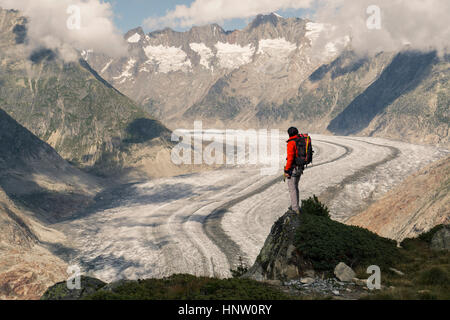 Kaukasischen Mann stehen auf Felsen in verschneiten Bergen Stockfoto
