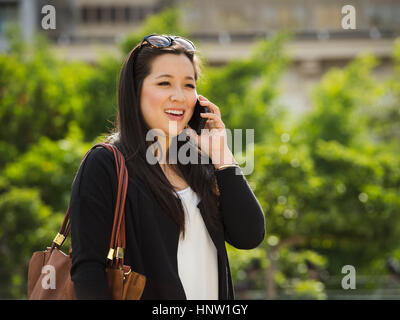 Chinesische Unternehmerin am Handy im freien sprechen Stockfoto