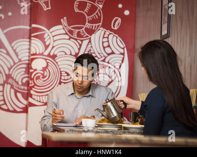 Chinesische Frau Gießen Tee im restaurant Stockfoto