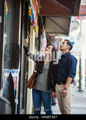 Neugierig chinesische paar Schaufensterbummel in Stadt Stockfoto