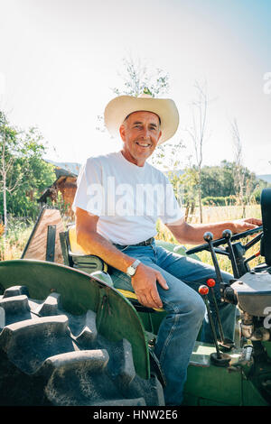 Kaukasische Bauer auf dem Traktor sitzen Stockfoto