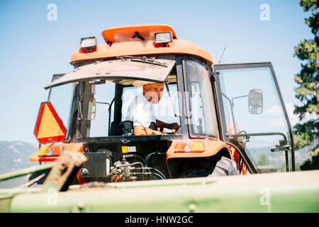 Kaukasische Landwirt treibende Traktor Stockfoto