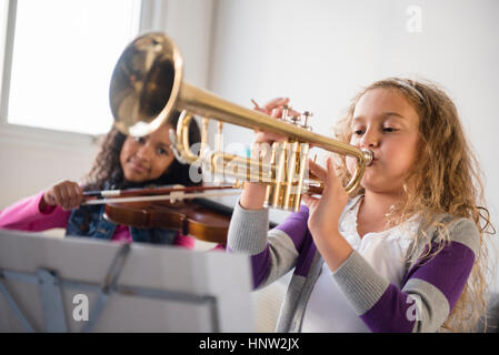 Mädchen üben spielen Violine und Trompete Stockfoto