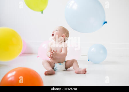 Kaukasischen jungen am Boden beobachten Ballons Stockfoto