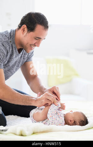 Hispanische Vater auf Bett mit Tochter spielen Stockfoto