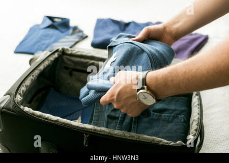 Mann-Verpackung-Pullover in Koffer Stockfoto