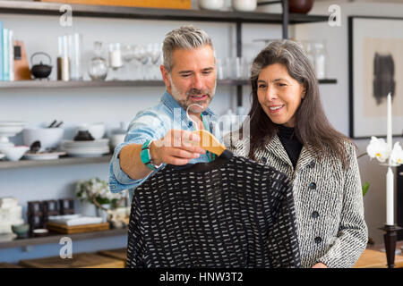 Mann zeigt Pullover Frau im store Stockfoto