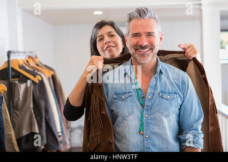 Frau, die Menschen helfen, mit Fransen Jacke im store Stockfoto