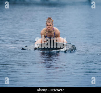 Kaukasische Frau heben schwere Reifen in See Stockfoto