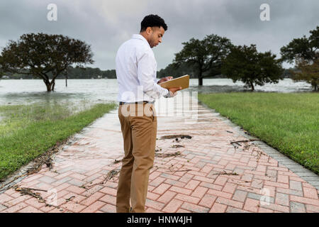 Schwarzen Versicherungssachverständigen Hochwasser Schäden untersuchen Stockfoto