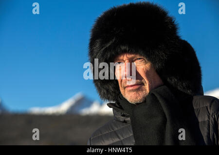Kaukasischen Mann mit Schal und Pelz Hut im winter