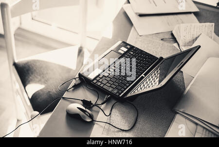 Arbeitstisch mit Laptop und viele schriftliche Arbeiten. Stockfoto