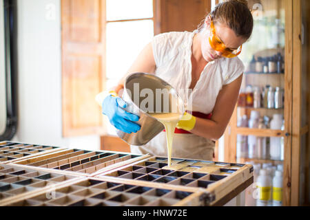 Junge Frau Gießen Flüssigkeit in Form von Seife handgemachte Seife Workshop Stockfoto