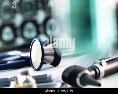 Des Arztes Schreibtisch mit Stethoskop auf Verschreibung Pads, Otoskop und MRT-Untersuchung am Computerbildschirm sitzen Stockfoto