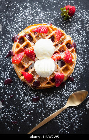 Erdbeeren und Eis Waffel auf Schiefer, bestreut mit Puderzucker, Draufsicht Stockfoto