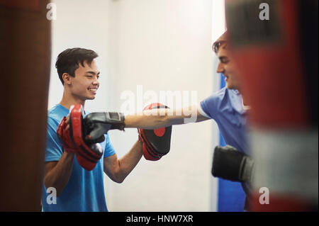 Männlicher Boxer Ausbildung, Stanzen Mitspieler Punch mitt Stockfoto