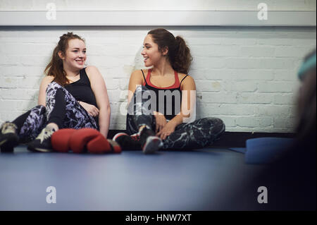 Zwei junge Boxerinnen sitzen auf Fitnessraum Etage im Chat Stockfoto