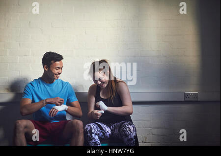 Junge männliche und weibliche Boxer Hände in Bandagen wickeln Stockfoto