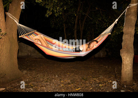 Junge Frau in Hängematte in der Nacht schlafen Stockfoto