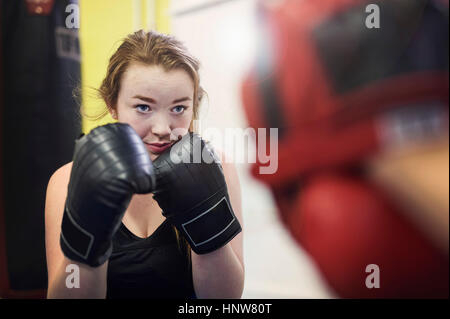 Junge Boxerin balanciert, um Feld Punch mitt Stockfoto