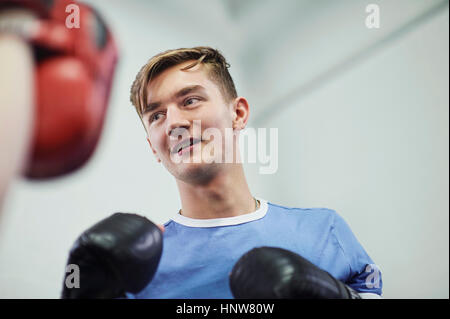 Junge männliche Boxer bereit, Box Punch mitt Stockfoto