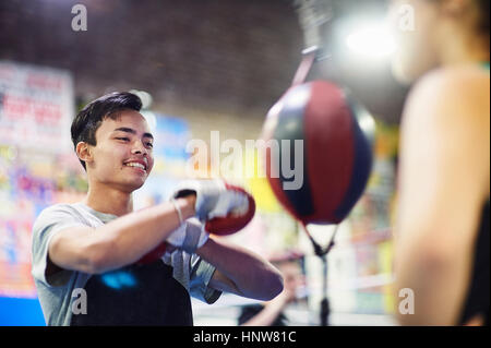 Junge männliche Boxer Stanzen Beinsack in Turnhalle Stockfoto