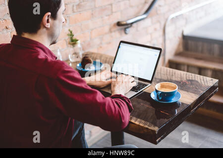 Mann arbeitet am Laptop im café Stockfoto