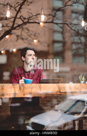 Mann auf der Suche durch Fenster des café Stockfoto