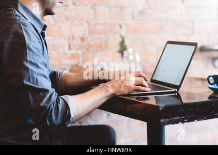 Mann arbeitet am Laptop im café Stockfoto