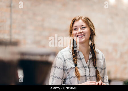 Glückliche junge Frau mit Zöpfen Stockfoto