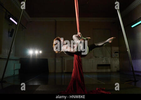 Junge weibliche Antenne Acrobat horizontal auf Seide Seil Stockfoto