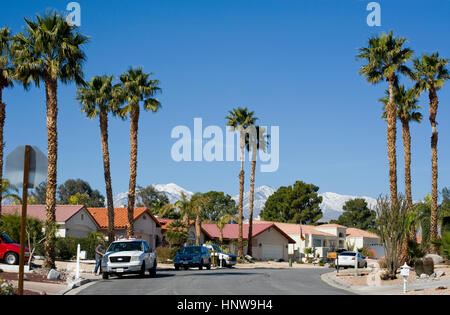 Häuser mit Palmen und Schnee in den Bergen in Palm Desert, Kalifornien Stockfoto