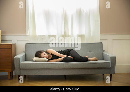 Frau düster auf sofa Stockfoto