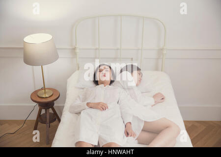 Frau depressiv auf Bett liegend Stockfoto