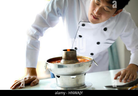 Koch auf der Suche und Prüfung am Essen, Tom Yum Goong, berühmten Thai scharf Hot pot Stockfoto