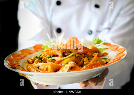 Stolz präsentieren Curry Krabben mit Kokosnuss in dunklen dramatischen Hintergrund Koch Stockfoto