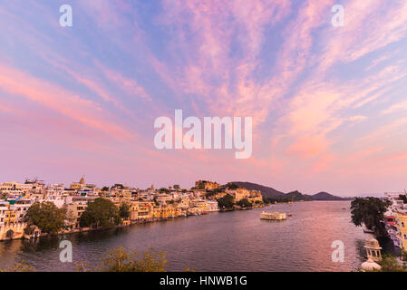 Udaipur Stadtbild mit bunten Himmel bei Sonnenuntergang. Das majestätische Schloss am Lake Pichola, Reiseziel in Rajasthan, Indien Stockfoto