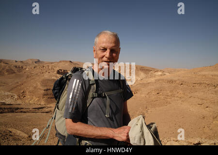 Ein ehrliches Porträt eines lächelnden 73-jährigen älteren Erwachsenen, eines Israelis und eines Wanderers in der Wüste. Über Nachal oder Nahal Marzeva, der Negev-Wüste, Israel. Stockfoto