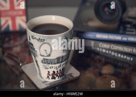 Weiße Tasse Kaffee mit Büchern Stockfoto