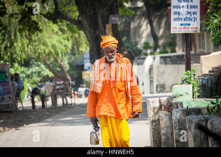 Rishikesh, Indien - 24. September 2014: Senior indischen Heiligen Mann in orange Gewand geht auf der Straße in Rishikesh, Indien am 24. September 2014. Stockfoto