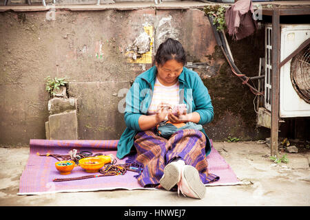 Dharamsala, Indien - 28. September 2014: tibetischer Frau mit einem Smartphone auf dem Straßenmarkt, Dharamsala, Indien. Stockfoto