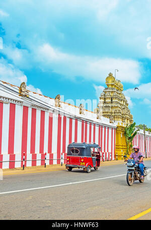 MUNNESWARAM, SRI LANKA - 25. November 2016: die bunte Wand des Munneswaram Tempels mit dem reich verzierten Tor, erstreckt sich entlang der Wariyapola Stockfoto