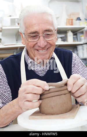 Senior woman bildet Coil Pot im Keramikatelier Stockfoto