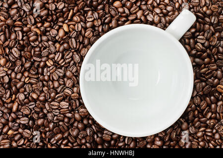 Overhead Schuss eine leere weiße Tasse über über einen frischen Hintergrund ganze Kaffeebohnen. Flache Laien Draufsicht Stil. Stockfoto